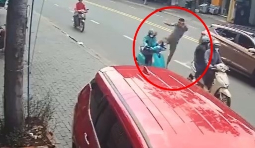 Người đàn ông đạp ngã cô gái lái xe ôm công nghệ đang lưu thông trên đường. Ảnh: Pháp Luật TP.HCM