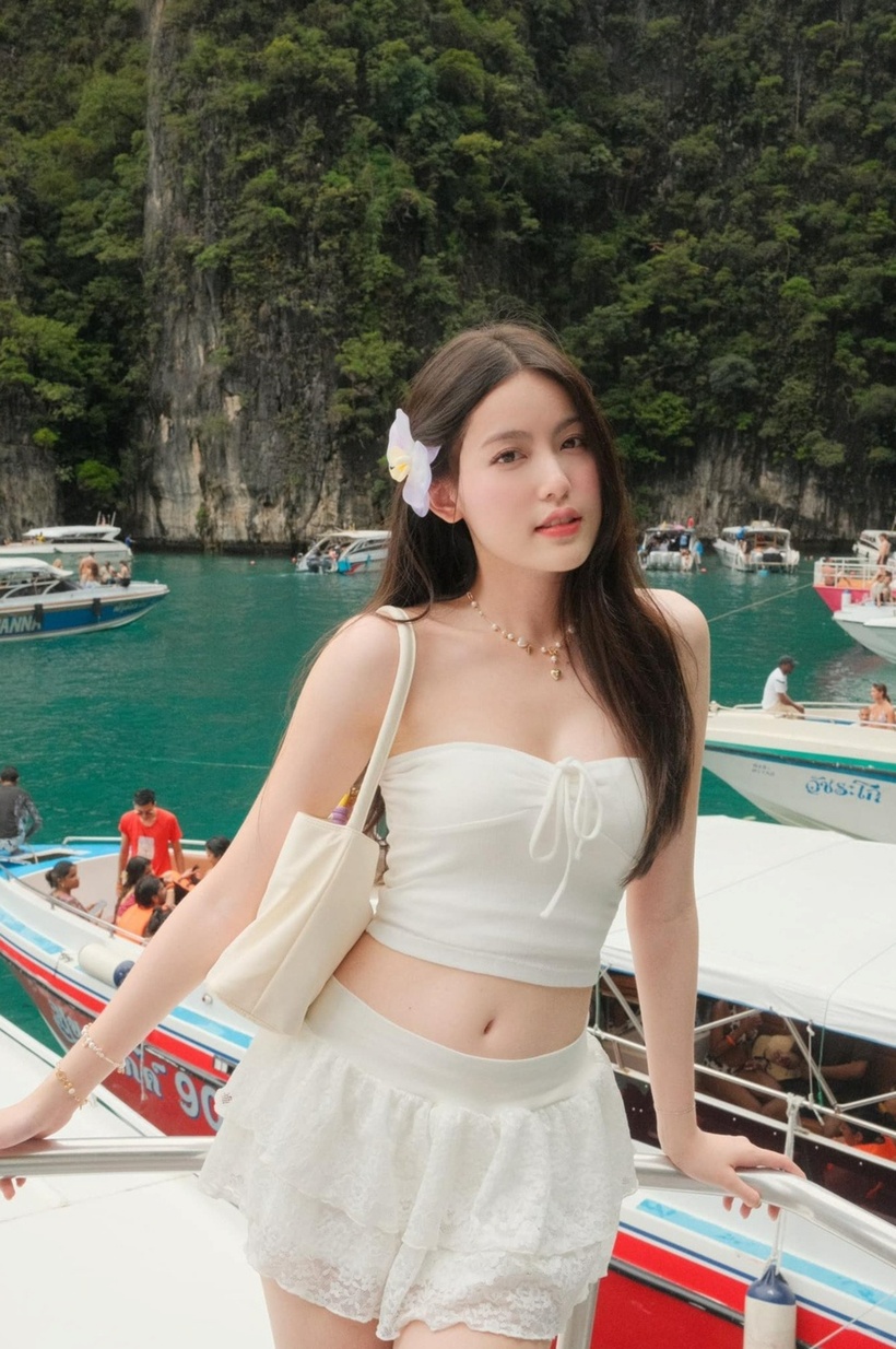 Ở những lần nghỉ dưỡng tại bãi biển, cô hiếm hoi khoe dáng với crop top và chân váy xếp ly. Người đẹp sinh năm 2003 kết hợp thêm vòng tay, dây chuyền và cài hoa mang lại nét ngọt ngào.