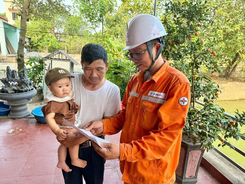Công nhân Điện lực trực thuộc PC Thanh Hóa thông tin và giải đáp các thắc mắc của khách hàng về chỉ số công tơ của gia đình sau khi thực hiện kiểm tra đảm bảo khách quan, minh bạch và công khai.