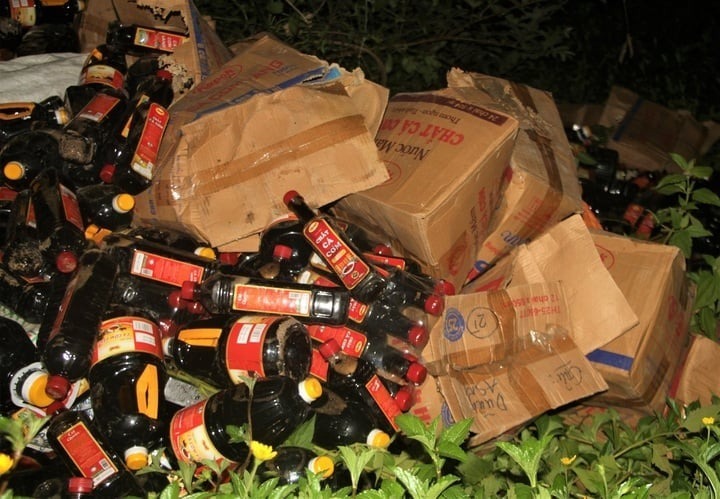 Hơn 1.000 chai nước mắm bị vứt trong bụi rậm ven đường ở Quảng Nam. Ảnh: VTC News