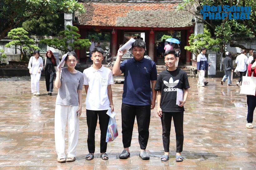 Em Hoàng Ngọc Tiến (áo xanh, học sinh của một trường THPT trên địa bàn huyện Đông Anh, Hà Nội) cùng nhóm bạn 3 người di chuyển đến Văn Miếu bằng xe máy. "Chúng em đi từ 8h sáng. Dù thời tiết mưa gió nhưng em và các bạn vẫn quyết tâm đến Văn Miếu để cầu may mắn cho kỳ thi tới. Mục tiêu của em là đạt khoảng 23 điểm để có thể thi đỗ vào Trường Đại học Mở Hà Nội", em Hoàng Ngọc Tiến cho biết.