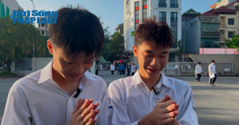 Em Trần Tuấn Hưng và em Ngô Xuân Đức chắp tay đọc bài cầu khấn tại điểm thi.