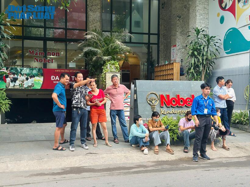 Nhiều phụ huynh hồi hộp ngồi đợi con trước cổng điểm thi.