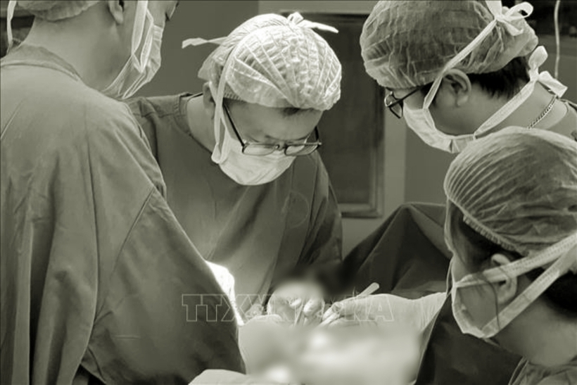 Ekip tiến hành ca phẫu thuật cho nam bệnh nhân. Ảnh: TTXVN