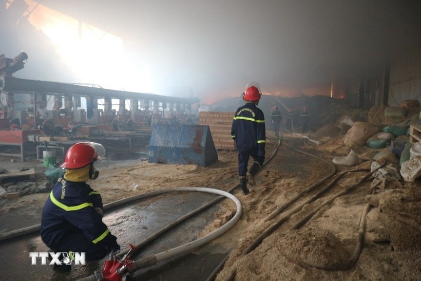 Bên trong xưởng chứa nhiều đồ dễ cháy như: nhựa, vải, gỗ nên việc chữa cháy đang gặp nhiều khó khăn. Ảnh: TTXVN/VietnamPlus