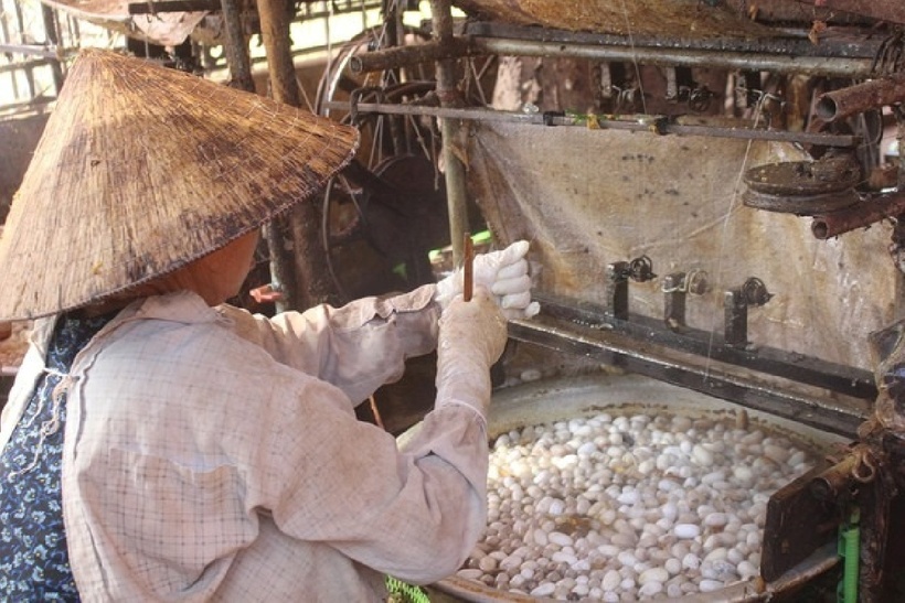 Người thợ đun kén trong nước sôi 100 độ C cho keo tơ tan ra để dễ dàng rút thành từng sợi. Ảnh: Gia đình và Xã hội.