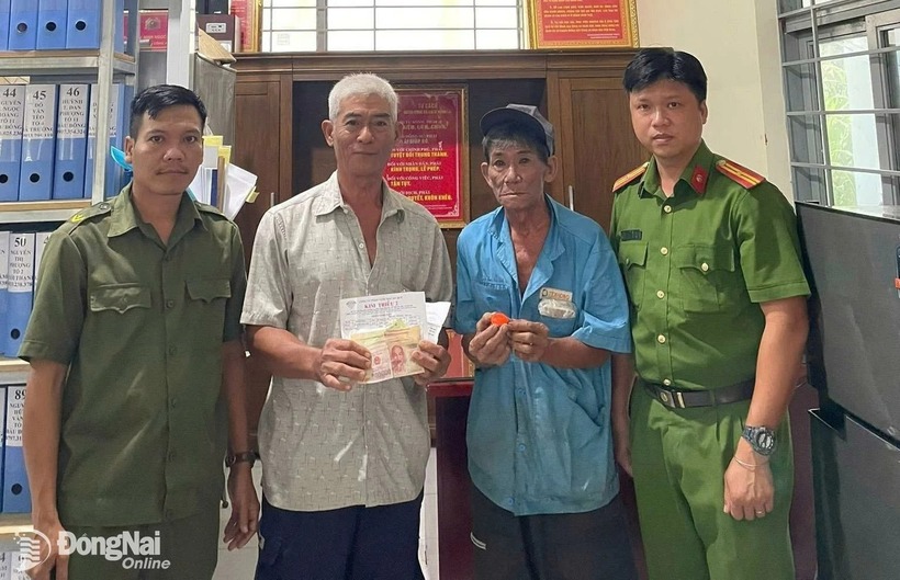 Trước sự chứng kiến của công an địa phương, ông Trương Văn Cà (thứ 2 từ phải qua) trao lại tài sản bị đánh rơi cho ông Nguyễn Văn Thành. (Ảnh: Báo Đồng Nai)