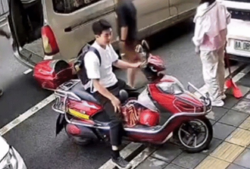 Con dao làm bếp từ trên cao rơi xuống suýt trúng người ngồi xe máy. Ảnh cắt từ clip