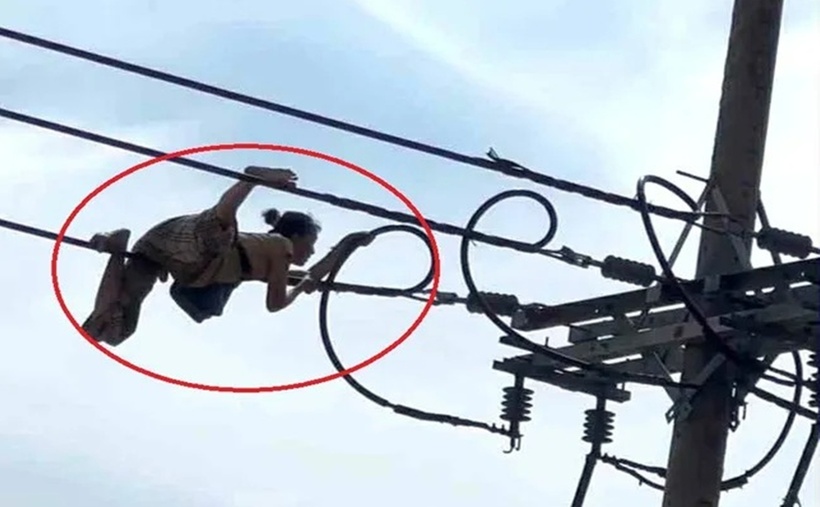 Người phụ nữ bò trên dây điện. (Ảnh: Tiền phong)