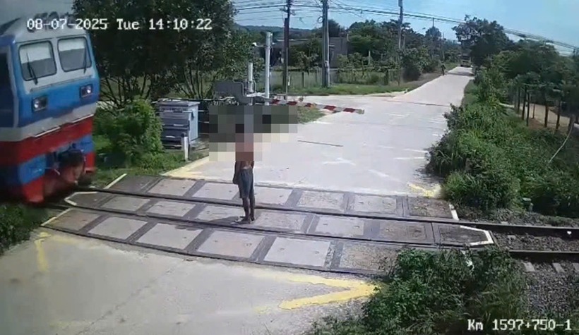 Người đàn ông đứng trên hành lang đường sắt, bị đoàn tàu lao tới tông trúng. Ảnh: Vietnamnet.