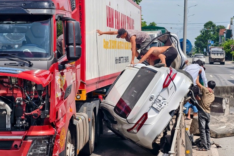 Người dân cứu 3 người trong ô tô gặp nạn. (Ảnh: Dân trí)