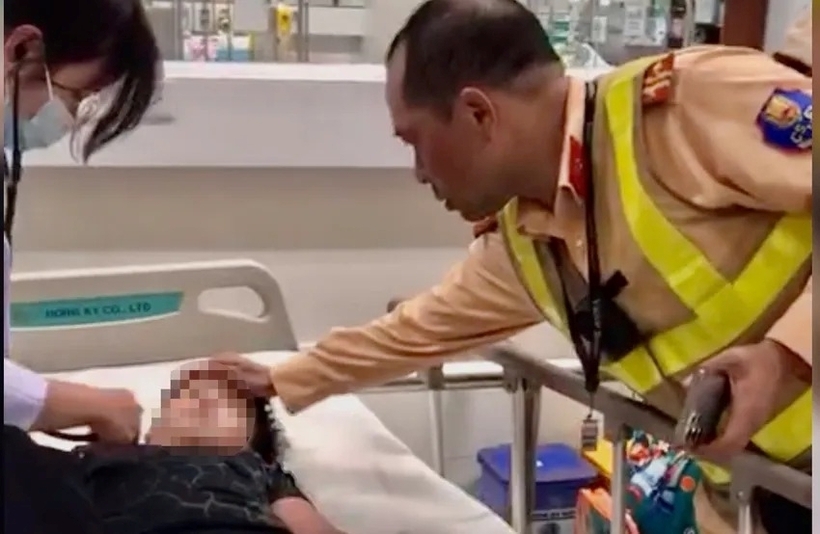 Cán bộ CSGT thăm hỏi, động viên cháu bé và gia đình. Ảnh: Tuổi trẻ