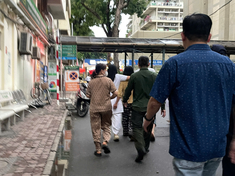 Khoảng hơn 18h, lực lượng chức năng đã đưa người phụ nữ (áo vàng, quần đen) xuống đất an toàn. Ảnh: PA