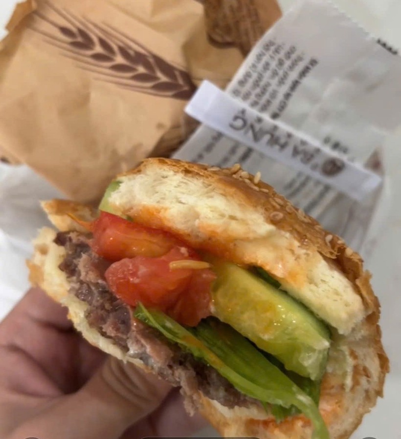 Dòi bò trong phần bánh hamburger được người dân phát hiện. (Ảnh: Dân Việt)