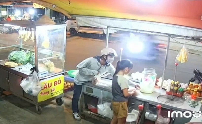 Camera ghi lại người đàn ông dàn cảnh mua đồ, lấy tiền bé gái bỏ chạy.