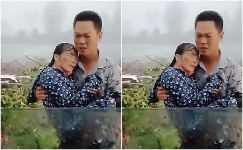 Anh Hiệp bế người phụ nữ đưa vào xe đi cấp cứu. (Ảnh: Cắt từ clip)