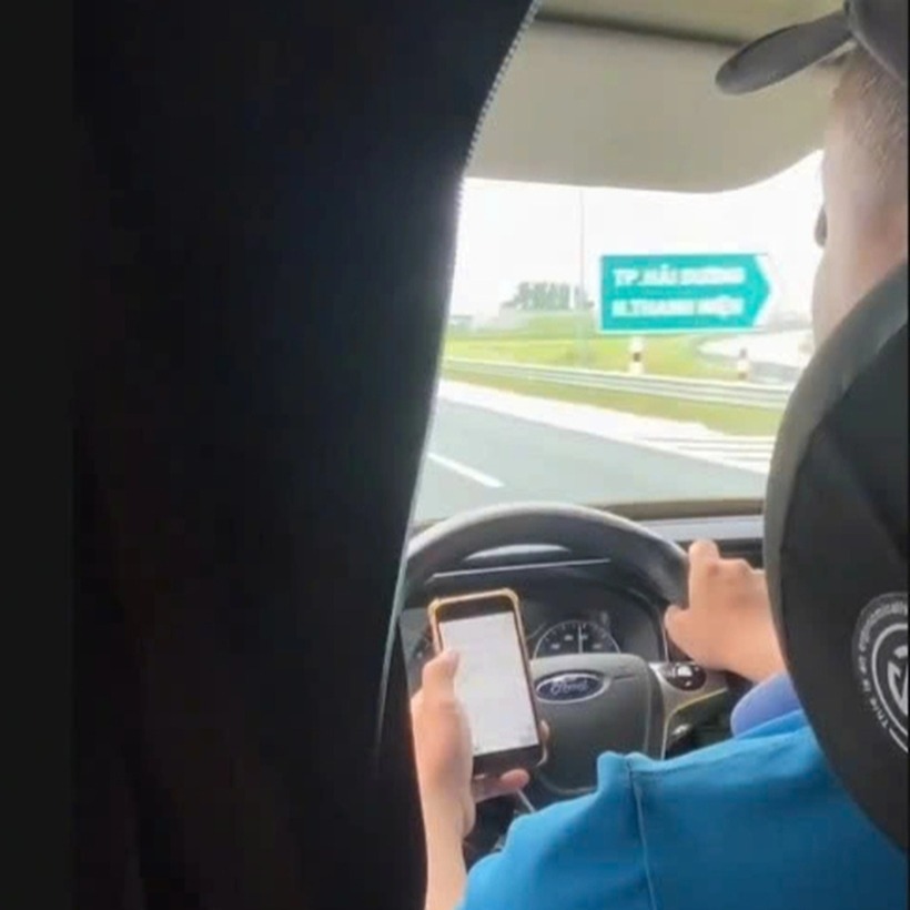 Tài xế vừa dùng điện thoại vừa lái xe trên cao tốc. Ảnh: Báo Dân trí.