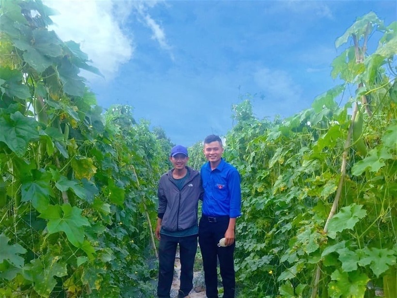 Anh Võ Xuân Đặng (trái) tại vườn mướp. Ảnh: Dân Việt