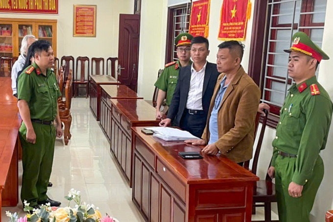 Ông Nguyễn Khắc Hùng (thứ 2 từ bên phải) khi cơ quan điều tra công bố quyết định tạm giam. Ảnh: VnExpress