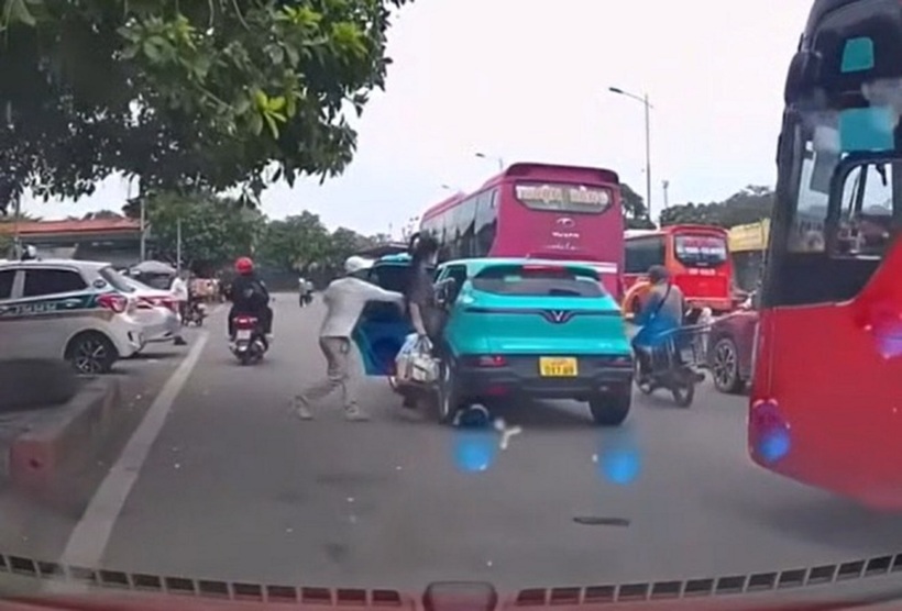 Người đàn ông đội mũ trắng ngăn cản cô gái lên xe taxi công nghệ. Ảnh cắt từ clip.