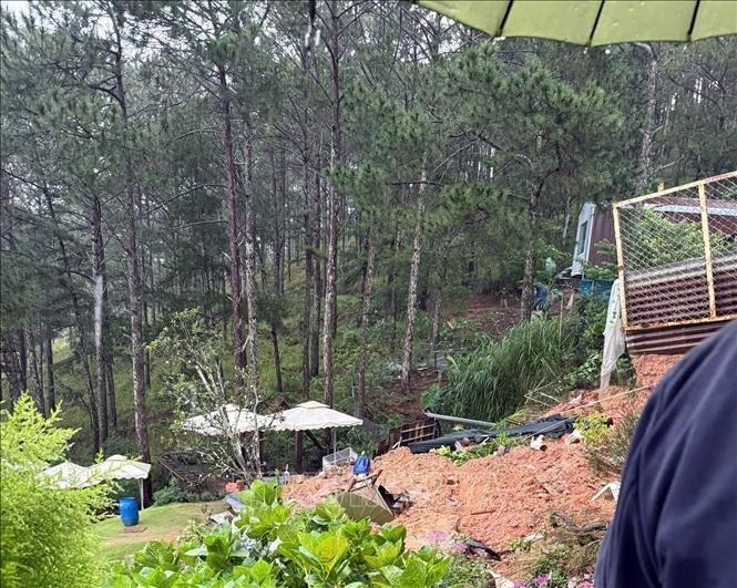 Bờ kè dài 20m sạt xuống cùng bùn đất vùi lấp làm 2 du khách ngồi uống cà phê tại quán cà phê Tây Hồ tử vong. (Ảnh: TTXVN)