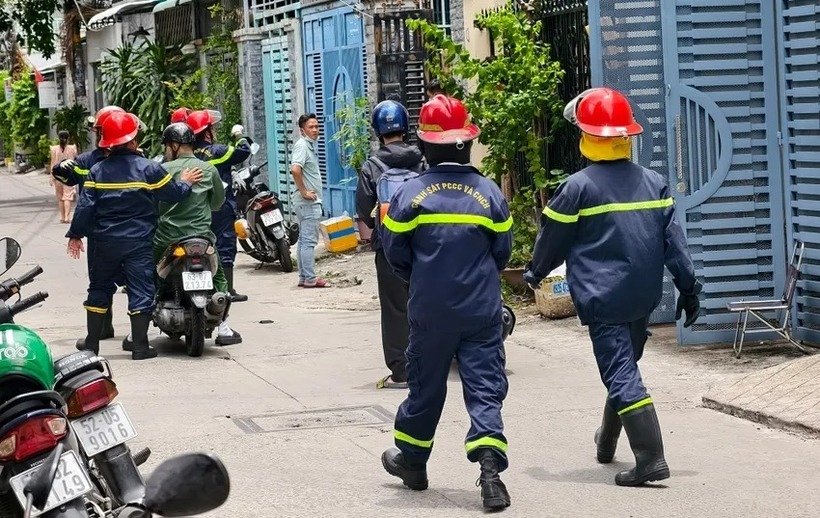 Lực lượng cảnh sát PCCC được huy động dùng phương tiện chuyên dụng phá cửa căn nhà. (Ảnh: PLO)