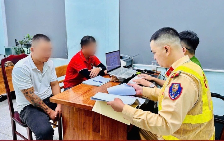 Lực lượng CSGT làm việc với phụ xe (áo đỏ) - người ngồi giữa Quốc lộ, chặn đầu xe khác. (Ảnh: Cơ quan công an)