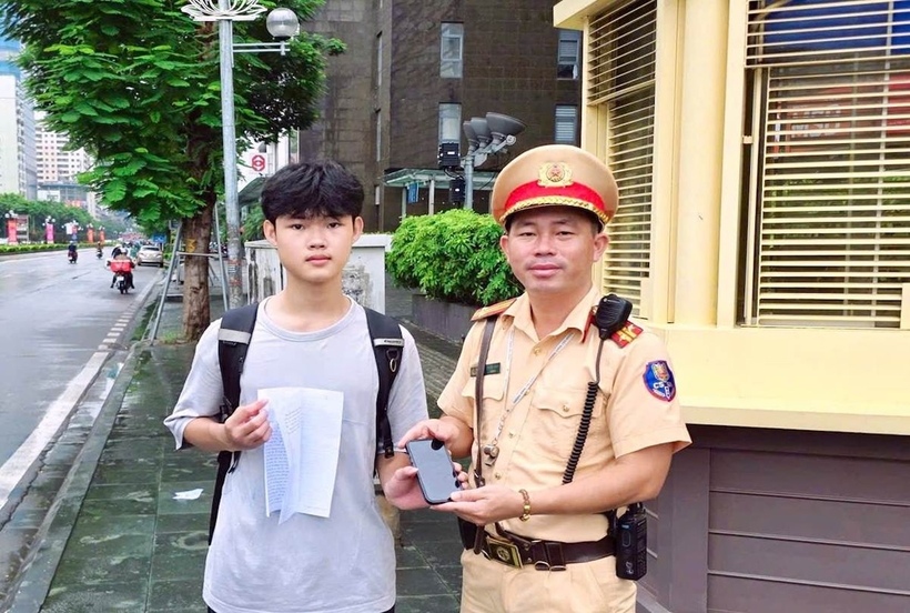 Cán bộ Đội CSGT đường bộ số 7 trao trả tài sản cho nam sinh đánh rơi trên đường