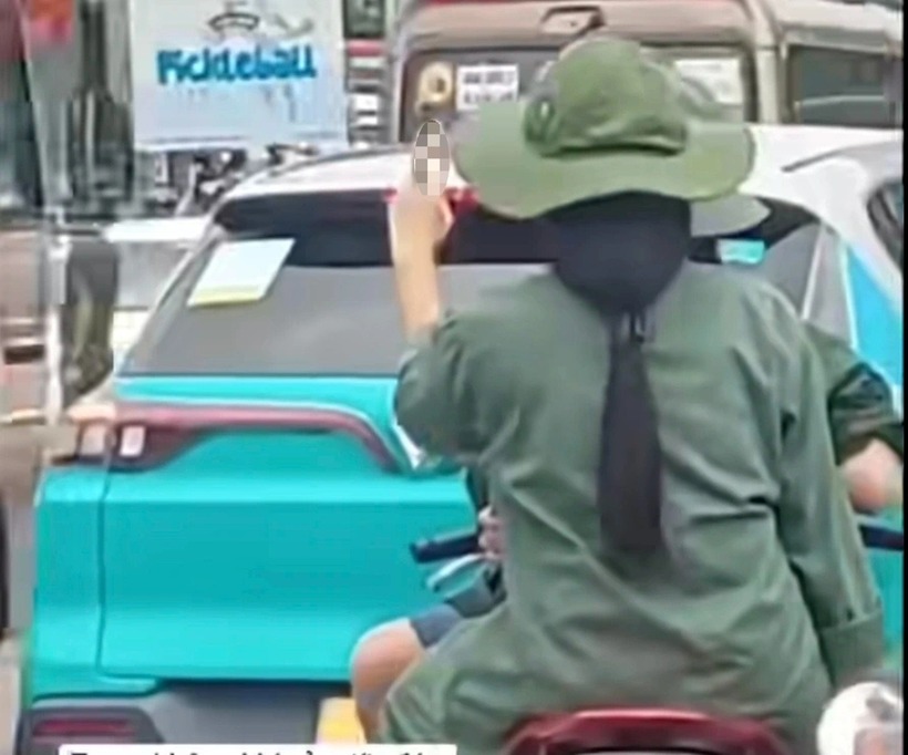 Một nữ sinh đưa tay có hành động khiếm nhã với đoàn xe A80. Ảnh: Báo Dân trí.