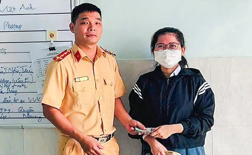 Đại úy Đào Văn Quyết trả lại giấy tờ tùy thân cùng số tiền 50 triệu cho chị Hằng. (Ảnh: Pháp luật TP.HCM)