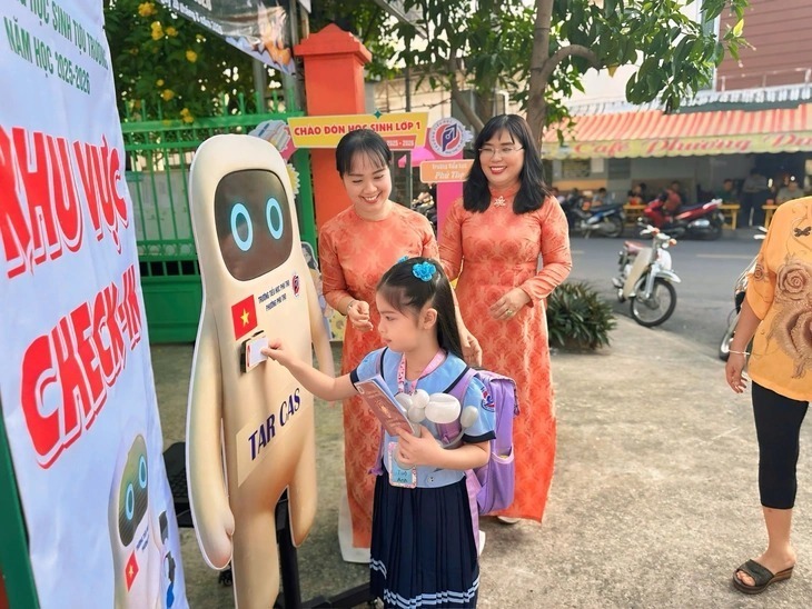 Ban giám hiệu trường và giáo viên ra tận cổng để đón chào học sinh lớp 1 trong ngày đầu tiên các em tựu trường. Ảnh: Tuổi trẻ Online