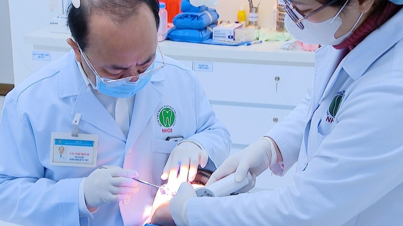 Bác sĩ Bệnh viện Răng hàm mặt trung ương kiểm tra tình trạng của bệnh nhân. Ảnh: Tuổi Trẻ.