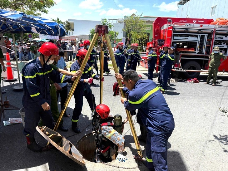 Lực lượng cảnh sát phòng cháy, chữa cháy và cứu nạn, cứu hộ (Công an Đà Nẵng) tiếp cận, đưa 2 nạn nhân từ dưới cống lên. (Ảnh: Tuổi trẻ)