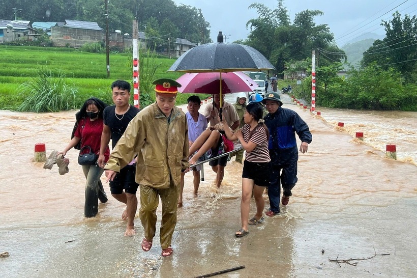 Cán bộ cùng lực lượng công an xã Mường Chanh vượt lũ, đưa sản phụ đi sinh an toàn. (Ảnh: UBND xã Mường Chanh)