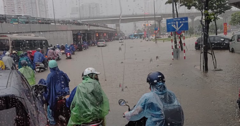 Ngã tư đi Phạm Văn Đồng - Hồ Tùng Mậu ngập khá sâu, các phương tiện di chuyển khó khăn. (Ảnh: NDCC)