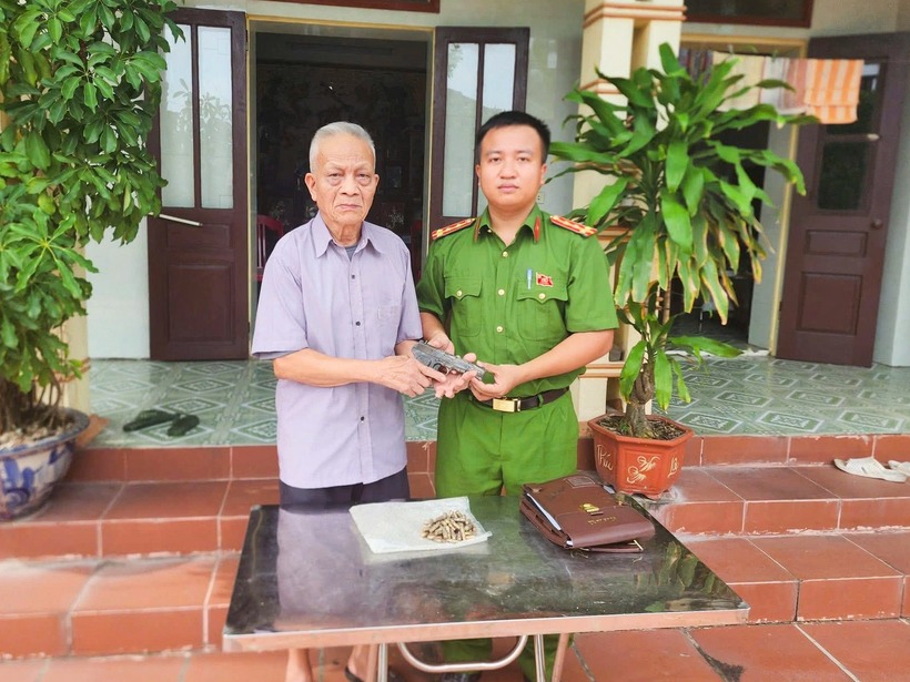 Ông Bùi Xuân Đ. bàn giao khẩu súng ngắn cho cơ quan công an địa phương. Ảnh: Vietnamnet