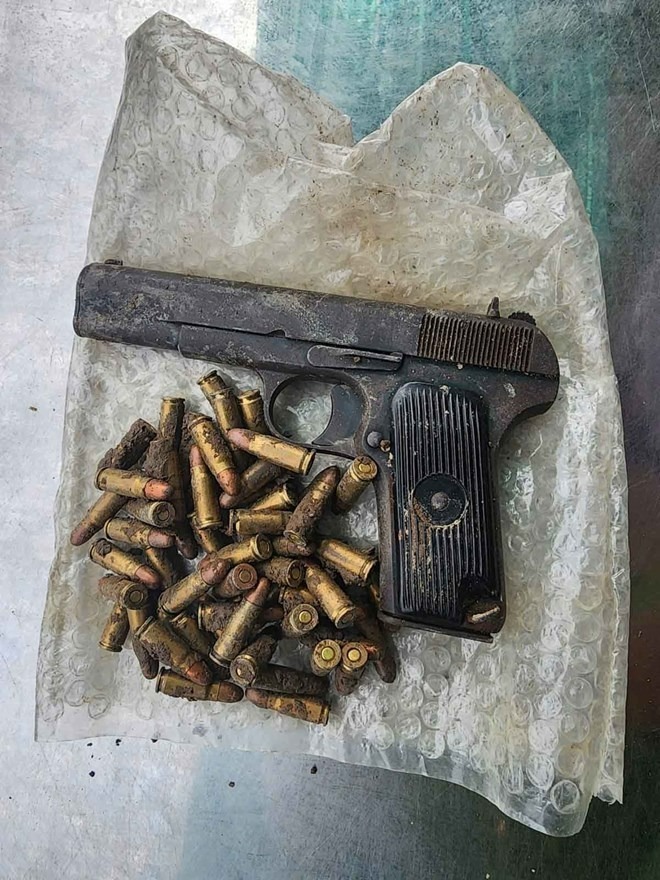Khẩu súng ngắn và 57 viên đạn. Ảnh: Lao động
