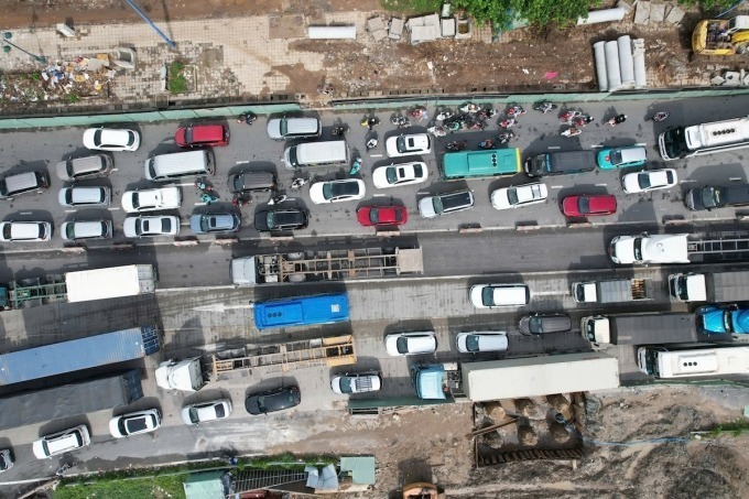 Xe máy phải len lỏi giữa khoảng trống các ôtô để di chuyển trong dòng xe ùn tắc kéo dài.