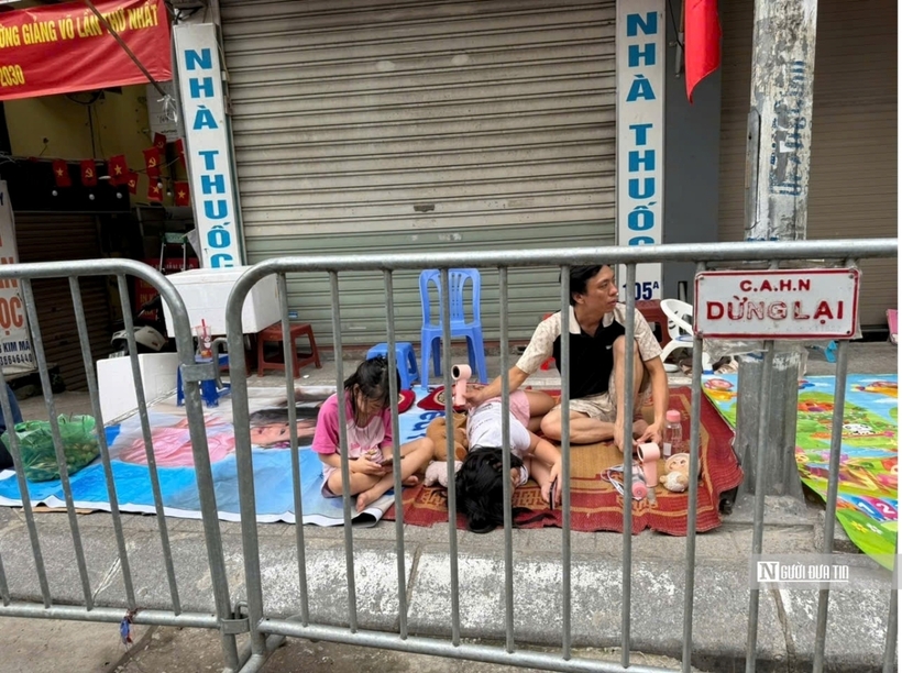 Một gia đình cho cả các em nhỏ ra giữ chỗ trên đường Kim Mã.