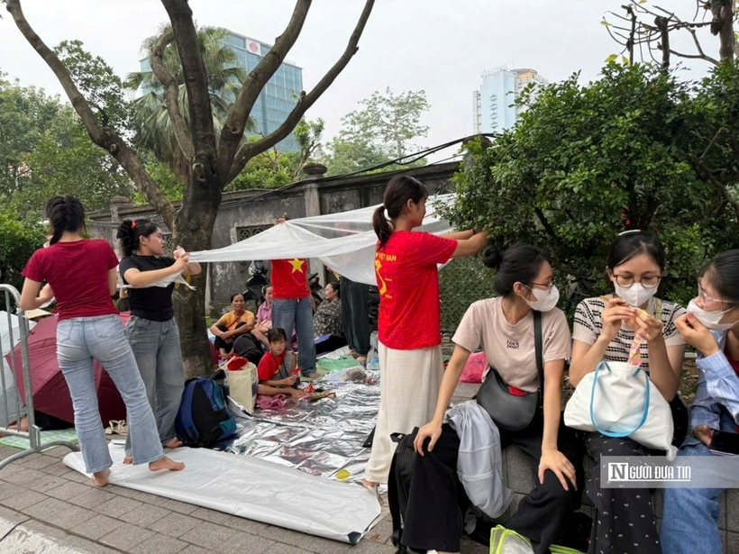 Người dân căng sẵn áo mưa, sẵn sàng ngủ qua đêm tại đây để chờ xem diễu binh, diễu hành.