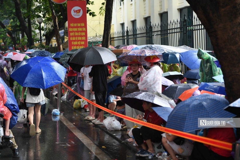 Người dân đội mưa chờ xem diễu binh, diễu hành.