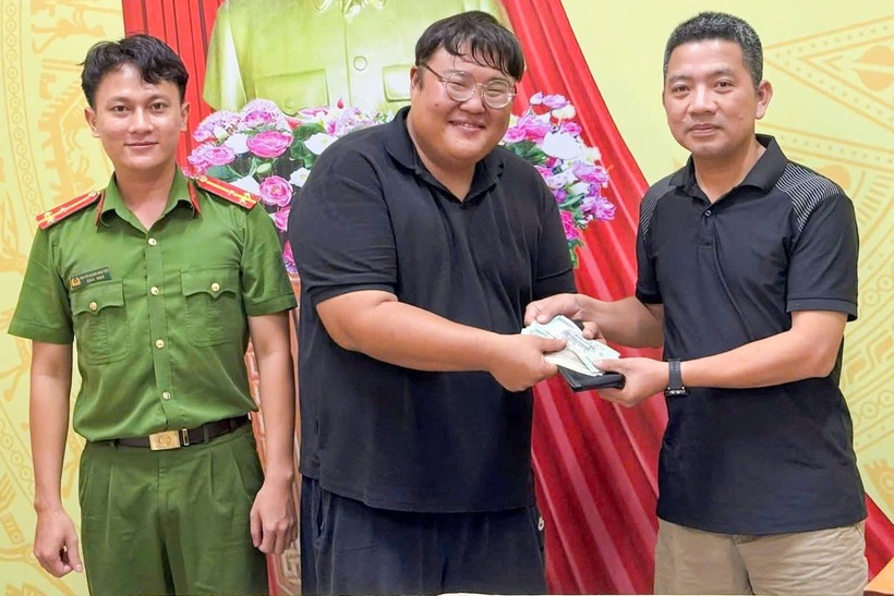 Du khách Hàn Quốc nhận lại chiếc túi bị đánh rơi. Ảnh: Dân Trí