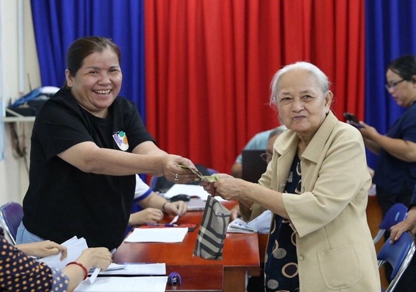 Cụ bà Nguyễn Thị Giàu (81 tuổi, ngụ phường Hòa Hưng) phấn khởi khi nhận quà 100.000 đồng. (Ảnh: Tuổi trẻ)