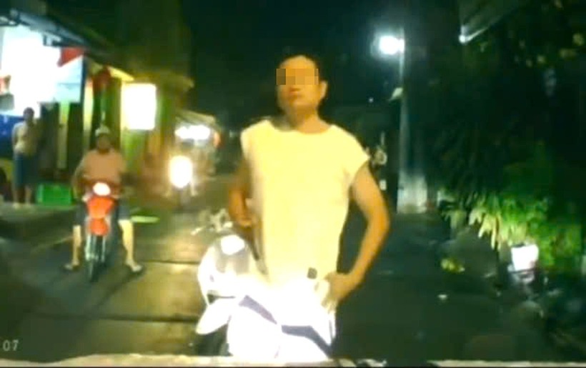 Người đàn ông chạy xe máy chở theo người phụ nữ không đội mũ bảo hiểm, chặn đầu ô tô, có hành động khiêu khích tài xế. Ảnh: Báo Dân trí.