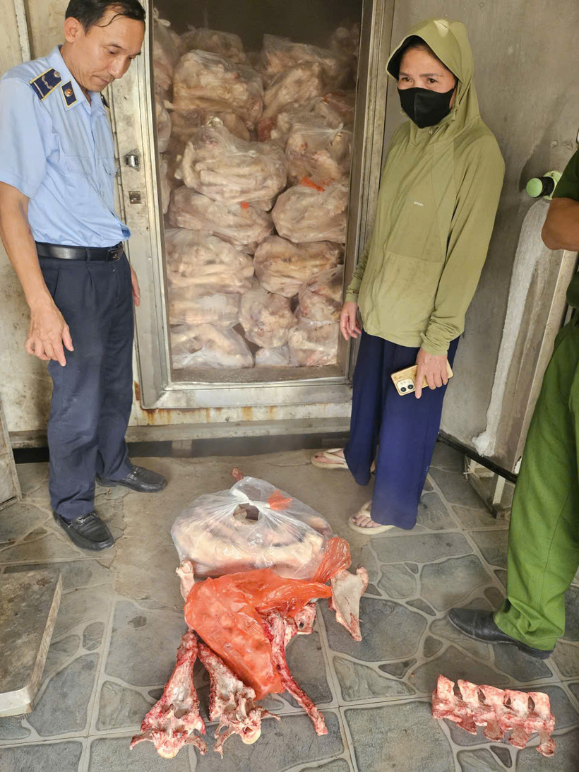 Lực lượng chức năng kiểm tra, phát hiện lô xương bò không rõ nguồn gốc tại cơ sở kinh doanh ở xã Vĩnh Thanh. Ảnh: QLTTHN