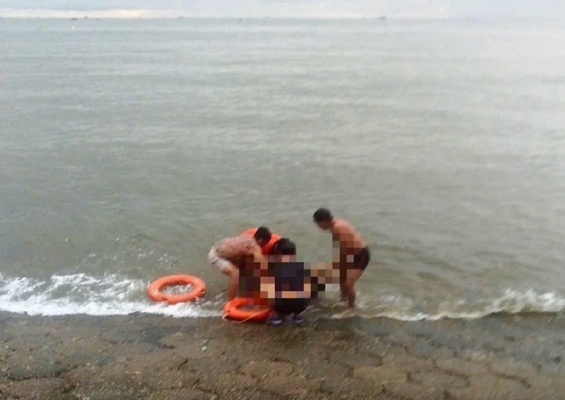 Người dân và lực lượng cứu hộ bờ biển đã vớt nạn nhân đưa vào bờ và sơ cứu. Ảnh: Báo Lao động.