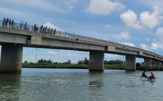 Lực lượng cứu hộ tìm kiếm, phát hiện thi thể nạn nhân dưới cầu. Ảnh: Lao động