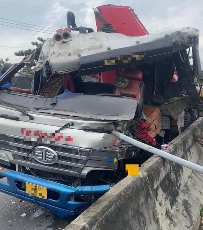 Vụ va chạm khiến kính chắn gió hư hỏng nặng, cánh cửa phía bên tài xế ngồi rơi khỏi cabin. Ảnh: Báo Người lao động.