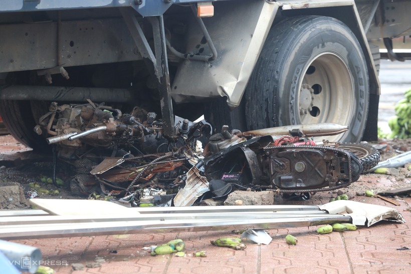 Một chiếc xe máy bị cuốn vào gầm xe tải bẹp dúm. (Ảnh: VNE)