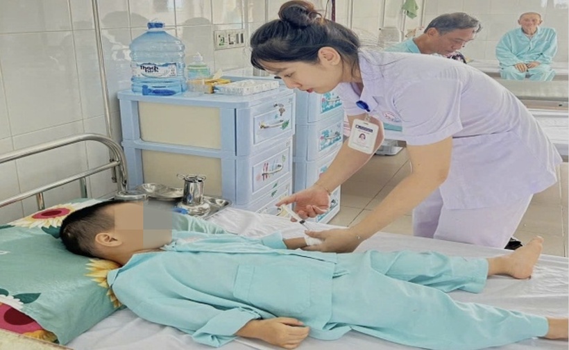 Nhân viên Y tế thăm khám cho cháu bé hóc dị vật pin "cúc áo". Ảnh: Tiền Phong.